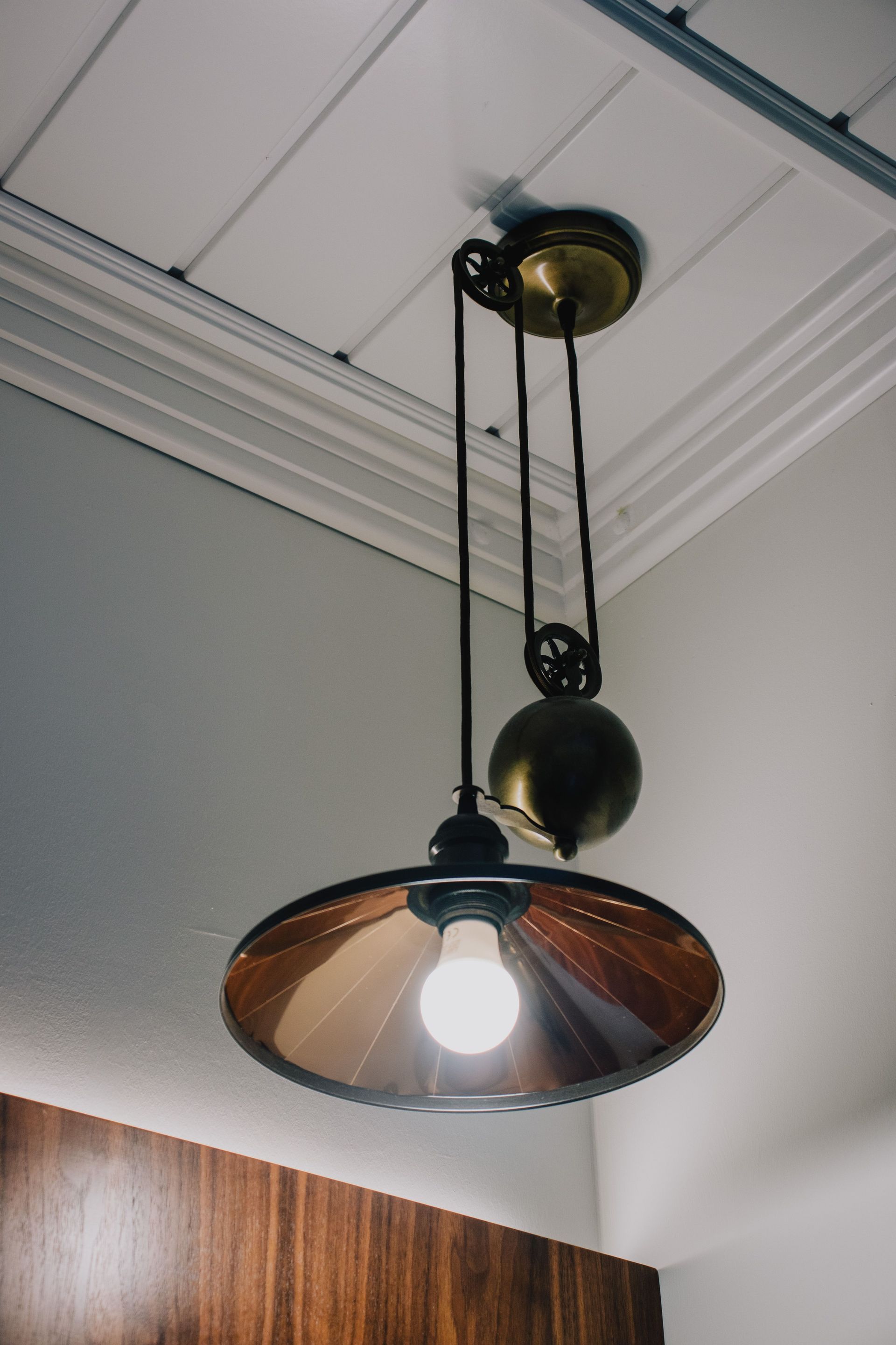 A vintage-style metal lamp hanging from the ceiling, showcasing classic interior decor.
